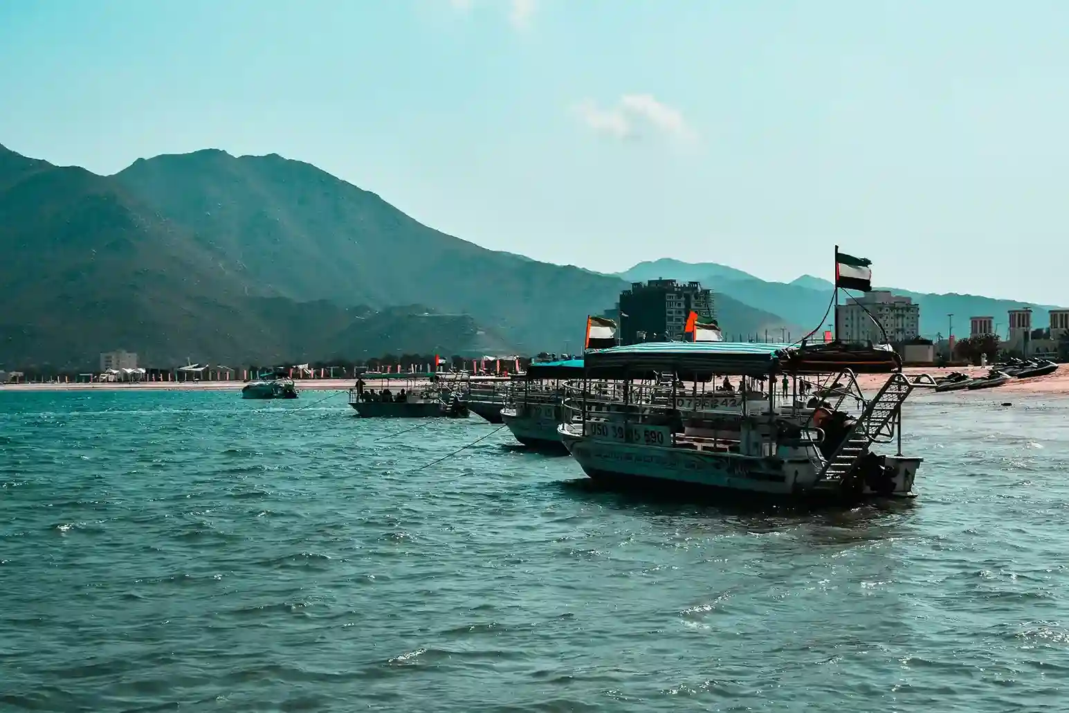 Khor Fakkan beach with mountains, clear water, and scenic coastal views