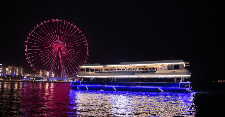 Dubai Marina skyline lit up at night, viewed from a dhow cruise boat during a dinner cruise